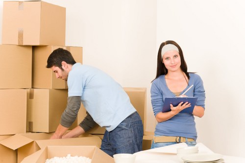 Professional movers loading furniture for transport in Hainault