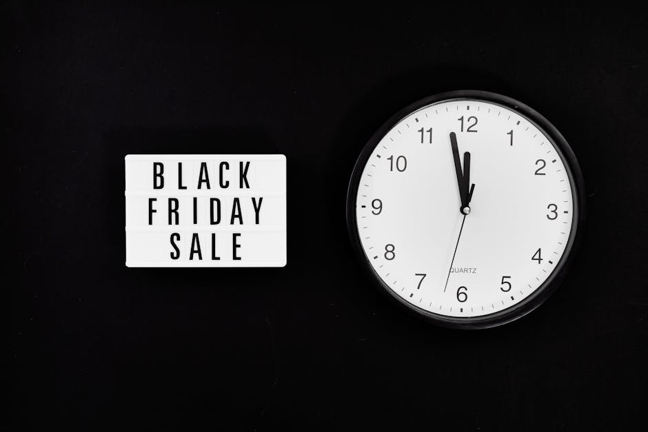 A black background with a white lightbox sign displaying the text 'BLACK FRIDAY SALE' in bold black letters on the left side of the image. To the right of the sign, there is a round, white, wall-mount